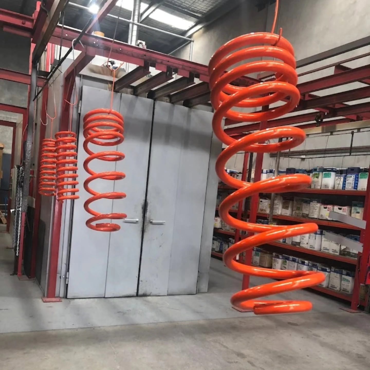 Colourful completed powder coating work hanging in the workshop